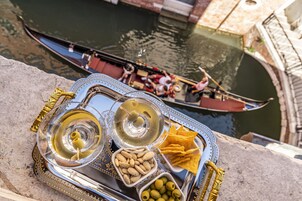 Un vassoio con olive, noci e cracker, con un panorama che include un gondola sullo sfondo.