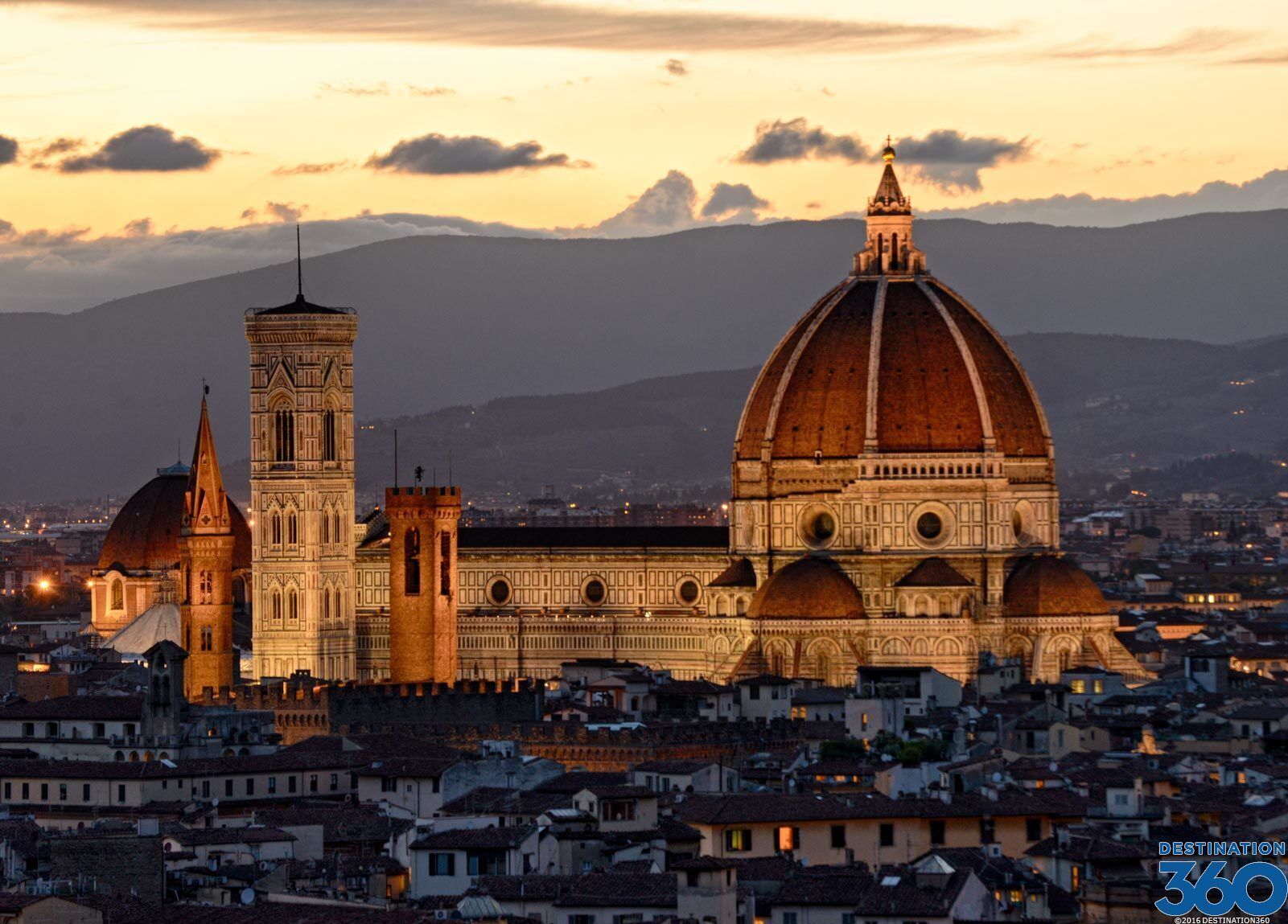 A historic building with a prominent dome and a bell tower, surrounded by a densely packed urban area.