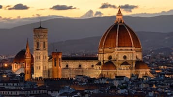 A historic building with a prominent dome and a bell tower, surrounded by a densely packed urban area.