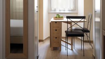 Un dormitorio pequeño con cama, escritorio y silla.