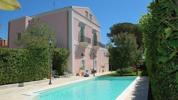 Een buitenzwembad en ligstoelen