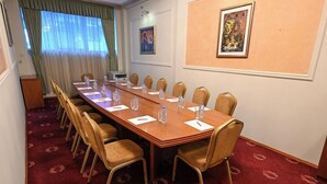 A conference room with a long table, chairs, water bottles, and name cards. - Stone Bridge Hotel (Skopje)
