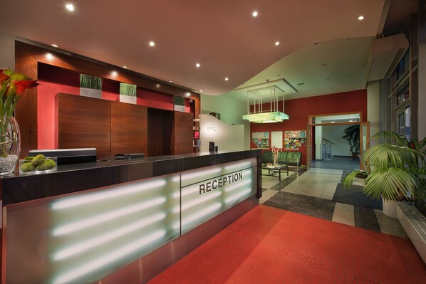 A reception area with a modern design, a reception desk, and a check-in counter.