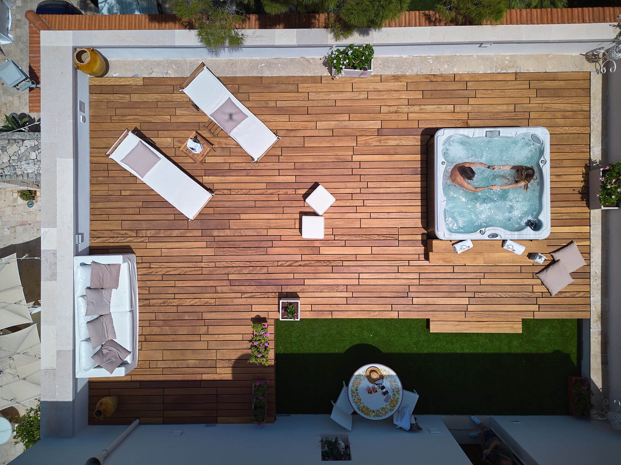 Una terraza en la azotea con jacuzzi, sillones de descanso y una pequeña mesa.