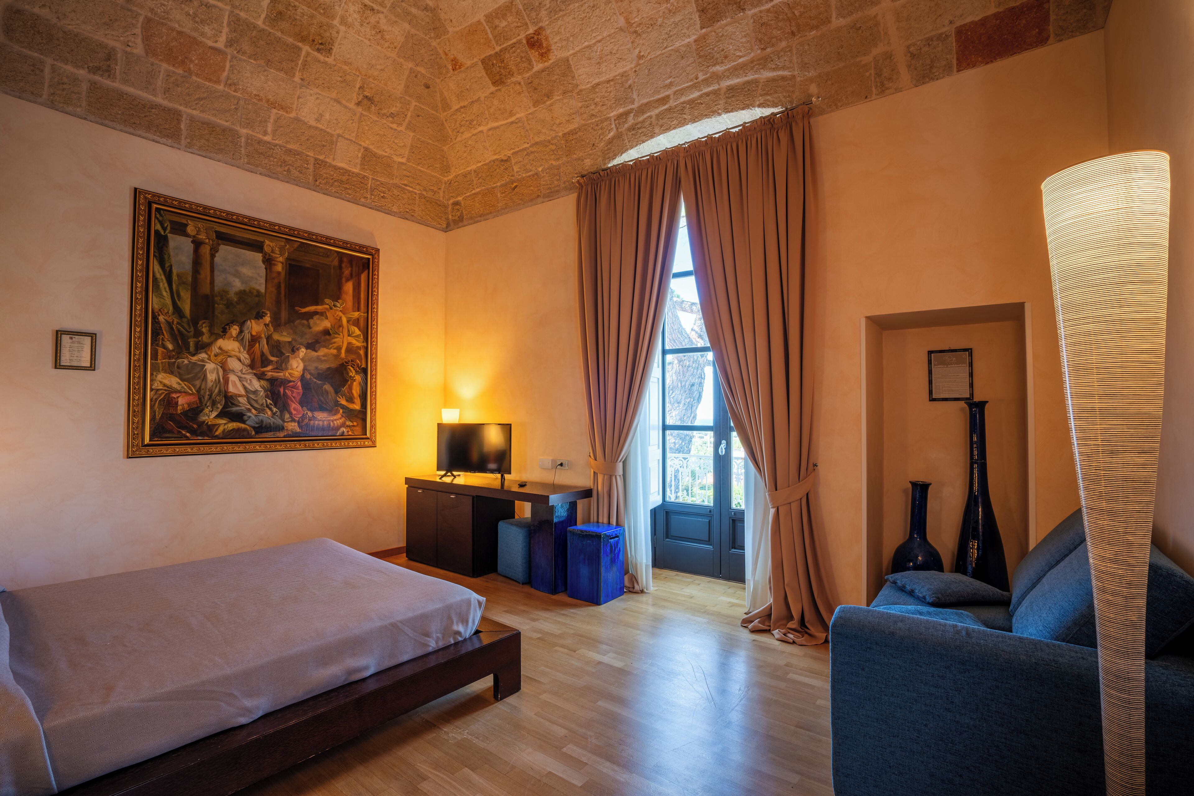 Una habitación con cama, escritorio, silla y un cuadro grande en la pared.