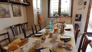 A dining table set with breakfast items, including bread, pastries, and beverages. - Sa Chessa (Ploaghe)