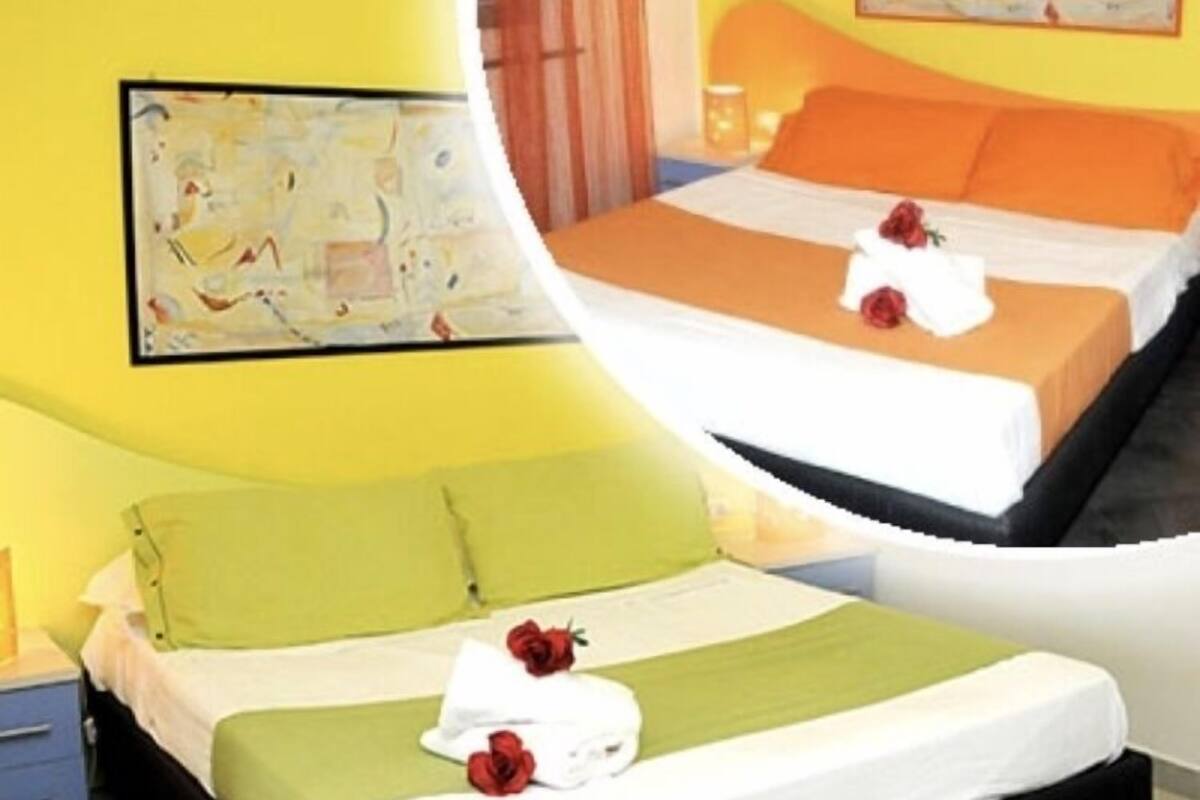 Ein Hotelzimmer mit Bett, Nachttisch, Lampe und einem Bild an der Wand.