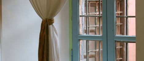 A window with a blue frame and a white curtain.