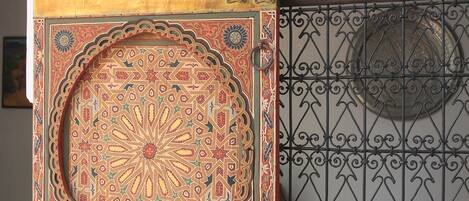Una puerta decorativa con diseños intrincados y un cerramiento de metal con un diseño circular.