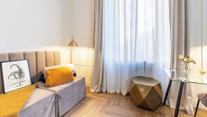 A modern living room with a sofa, a geometric coffee table, and a framed artwork on the wall. - Hotel Catone (Rome)