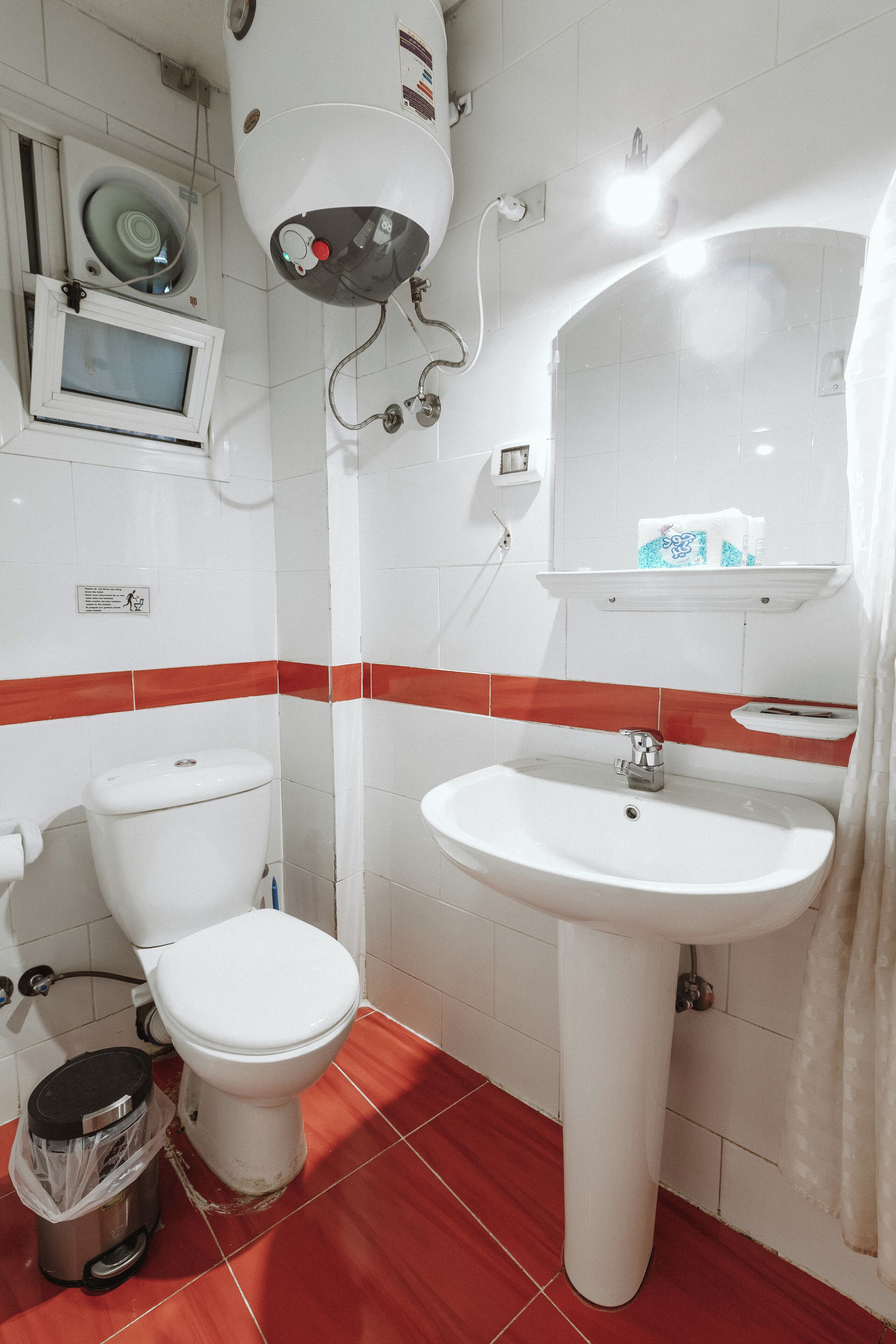 Une salle de bain avec des toilettes, un lavabo et un miroir.