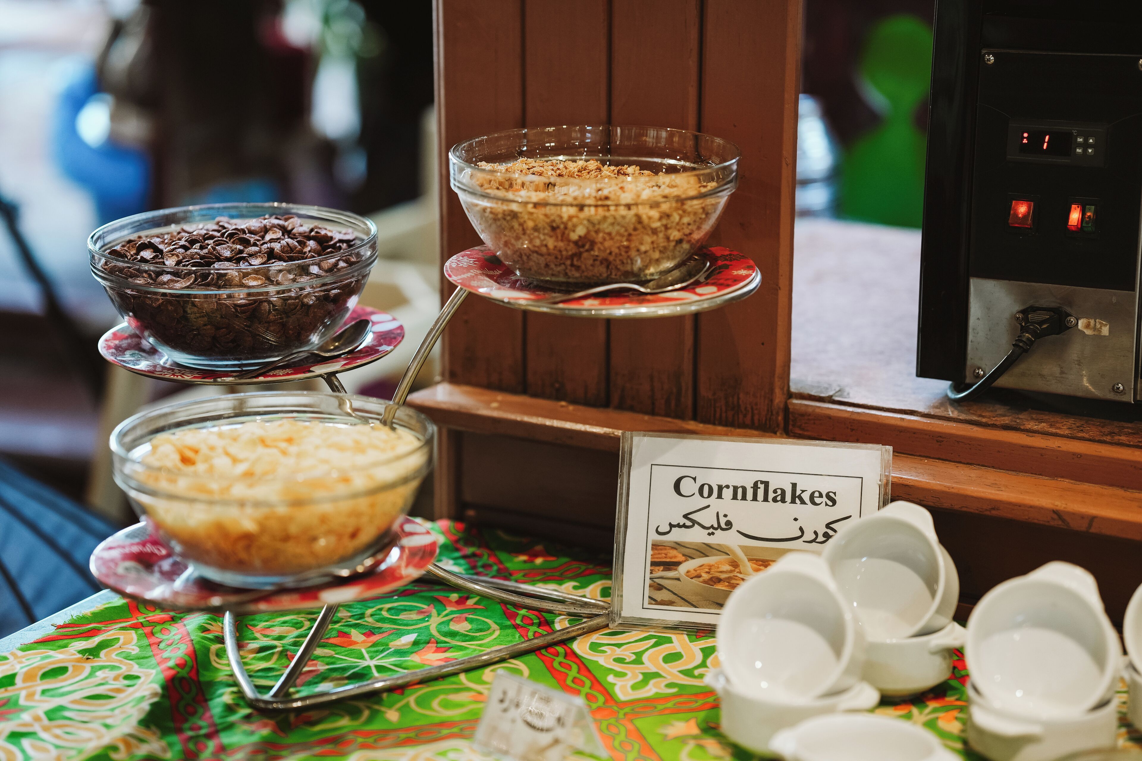 A buffet with bowls of cornflakes and chocolate chips.