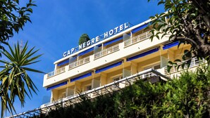 A hotel with a sign reading "Cap Negre Hotel". It has multiple balconies and a clear blue sky in the background. - Cap Nègre Hôtel (Le Lavandou)