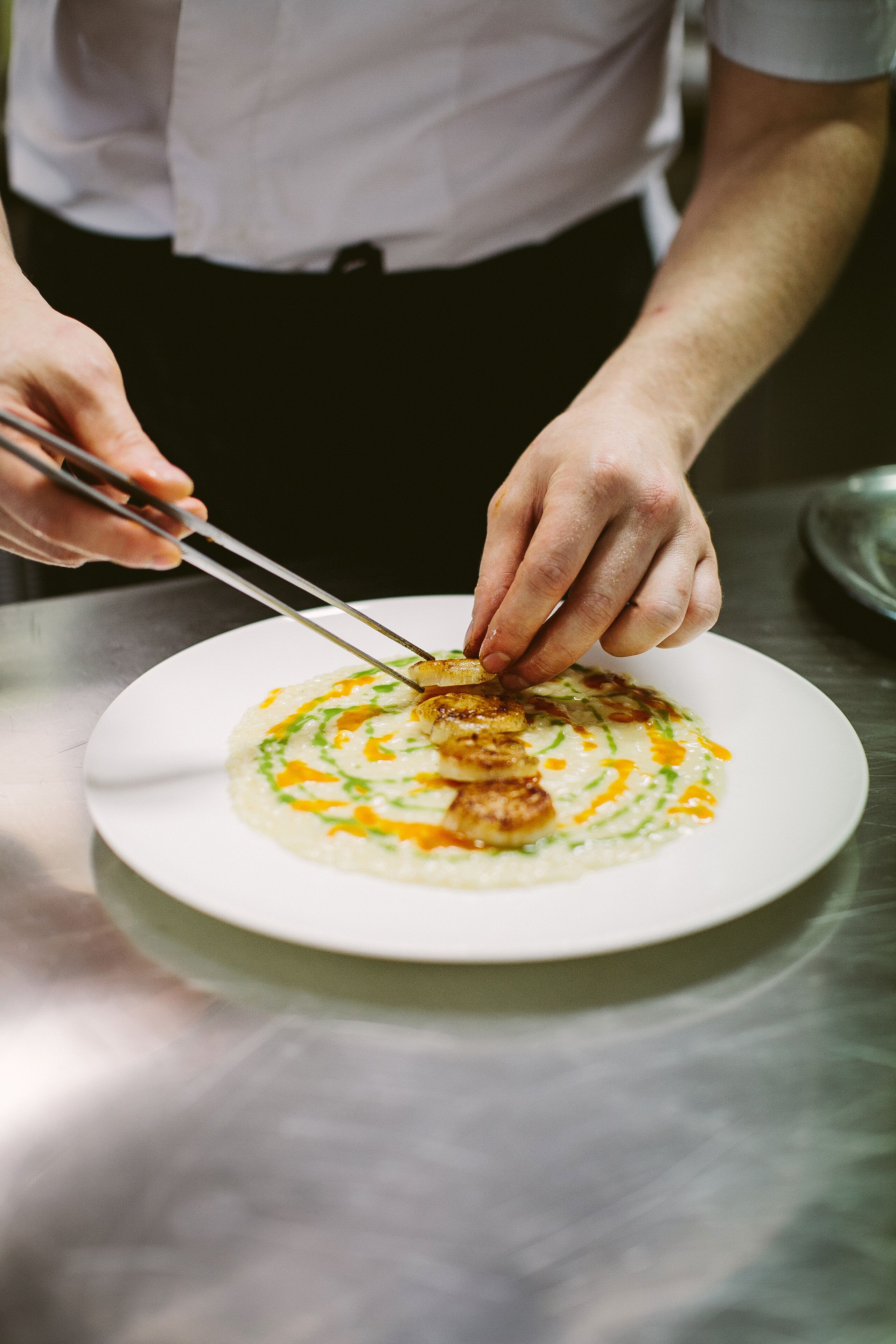 A person serving food on a white plate.