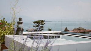 Un bain à remous avec vue sur la mer et les bâtiments situés au loin.