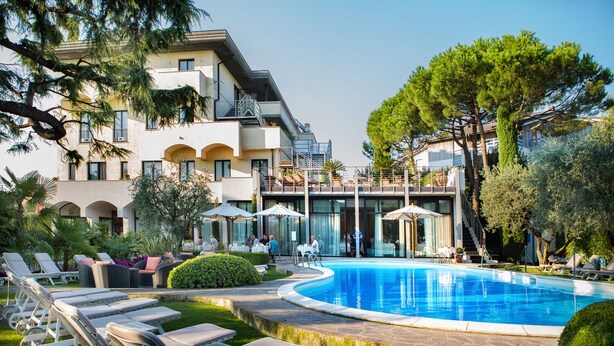 Un complexe hôtelier doté d’une piscine, de chaises longues et d’espaces de détente en plein air.