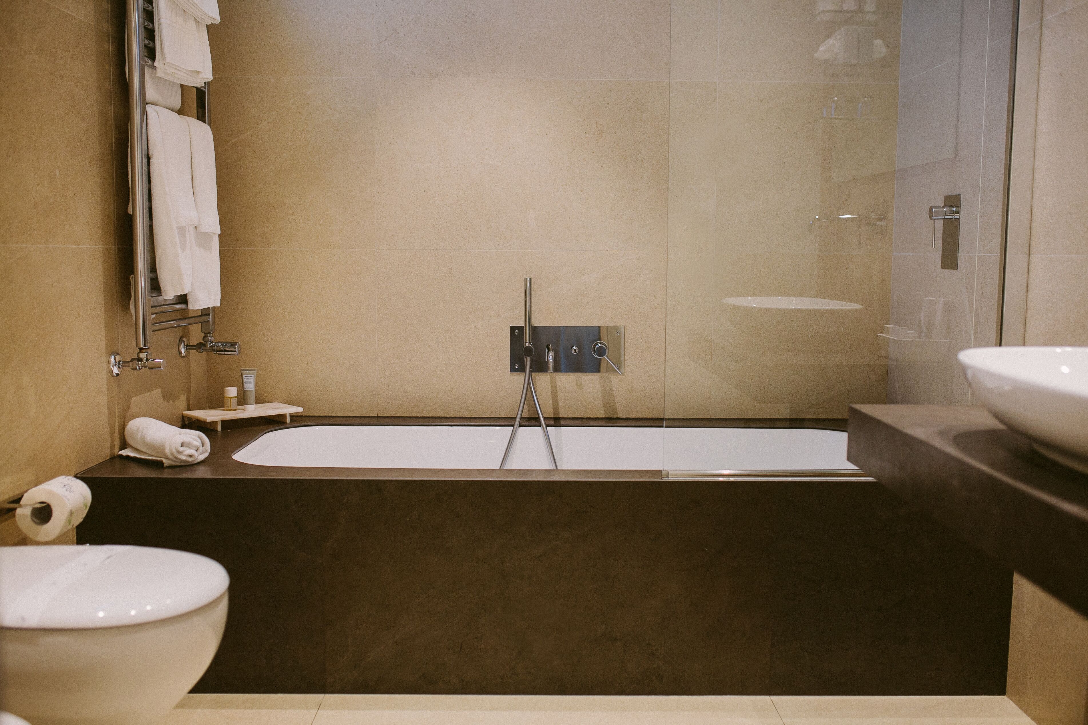 Une salle de bain moderne équipée d’une baignoire, de toilettes et d’un lavabo.