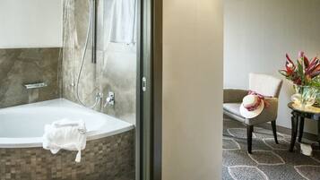A bathroom with a bathtub, shower, and glass-enclosed shower area.
