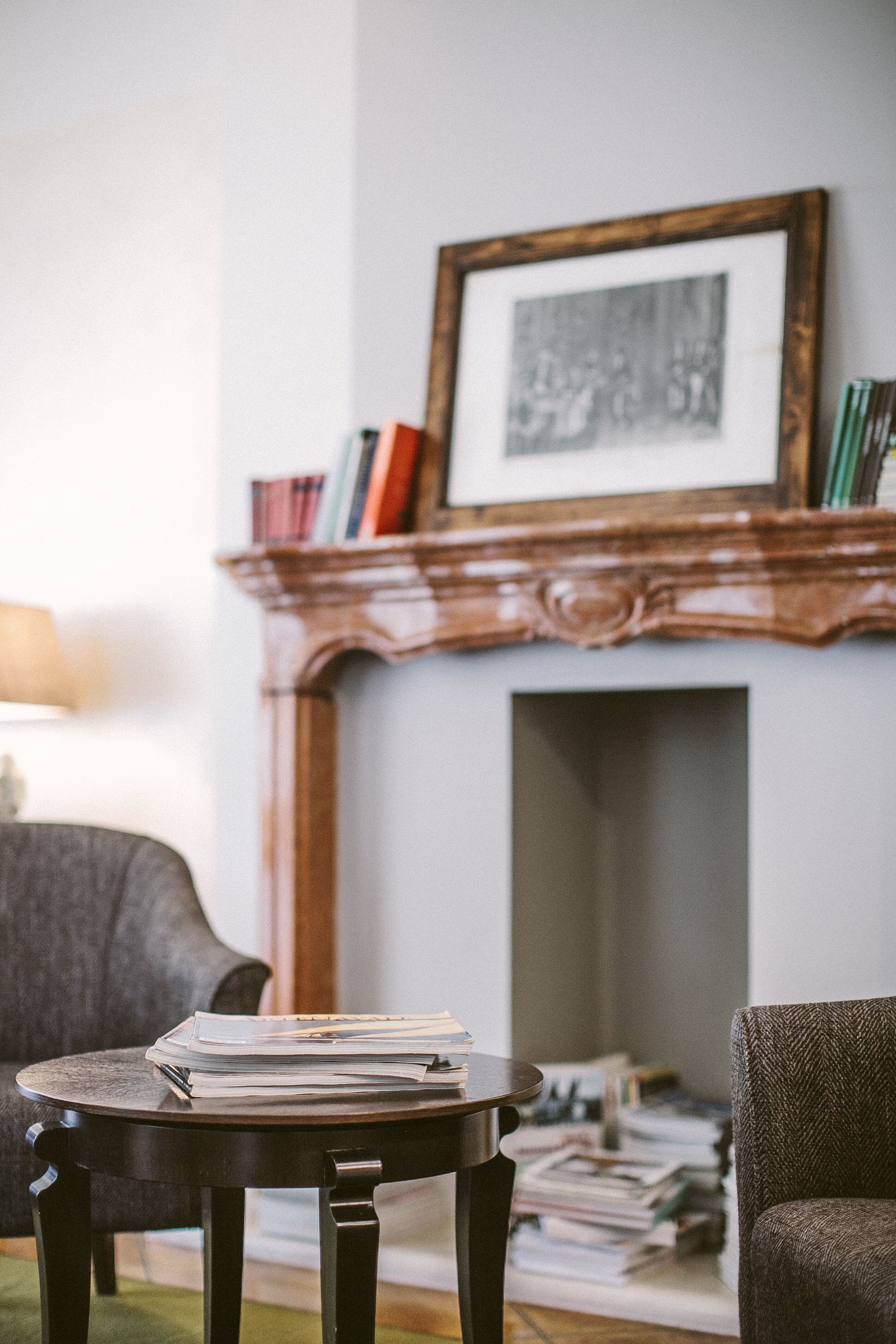 A room with a fireplace, a bookshelf, and a table with papers.