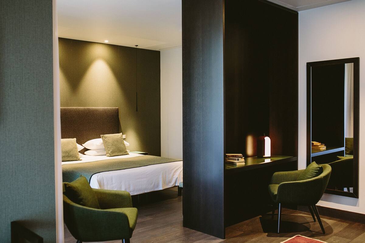 Ein modernes Hotelzimmer mit einem Bett, einem Schreibtisch und zwei Stühlen.