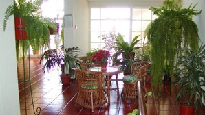 A dining area with wicker furniture and potted plants. - Vila Marta (Funchal)