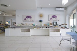 Una cocina moderna con barra americana, armarios blancos y decoración mural.