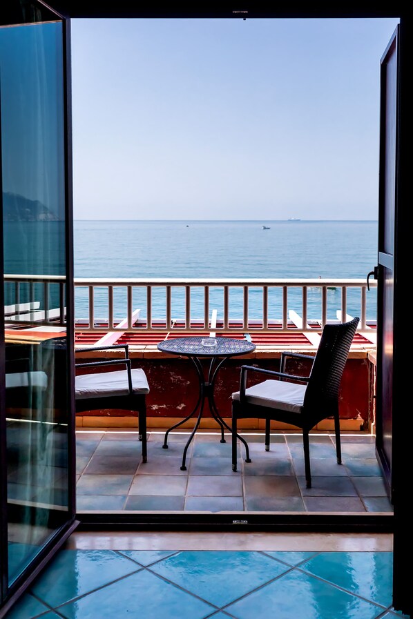 A balcony with a table and two chairs, overlooking a body of water. - Hotel Polo Nautico (Salerno)