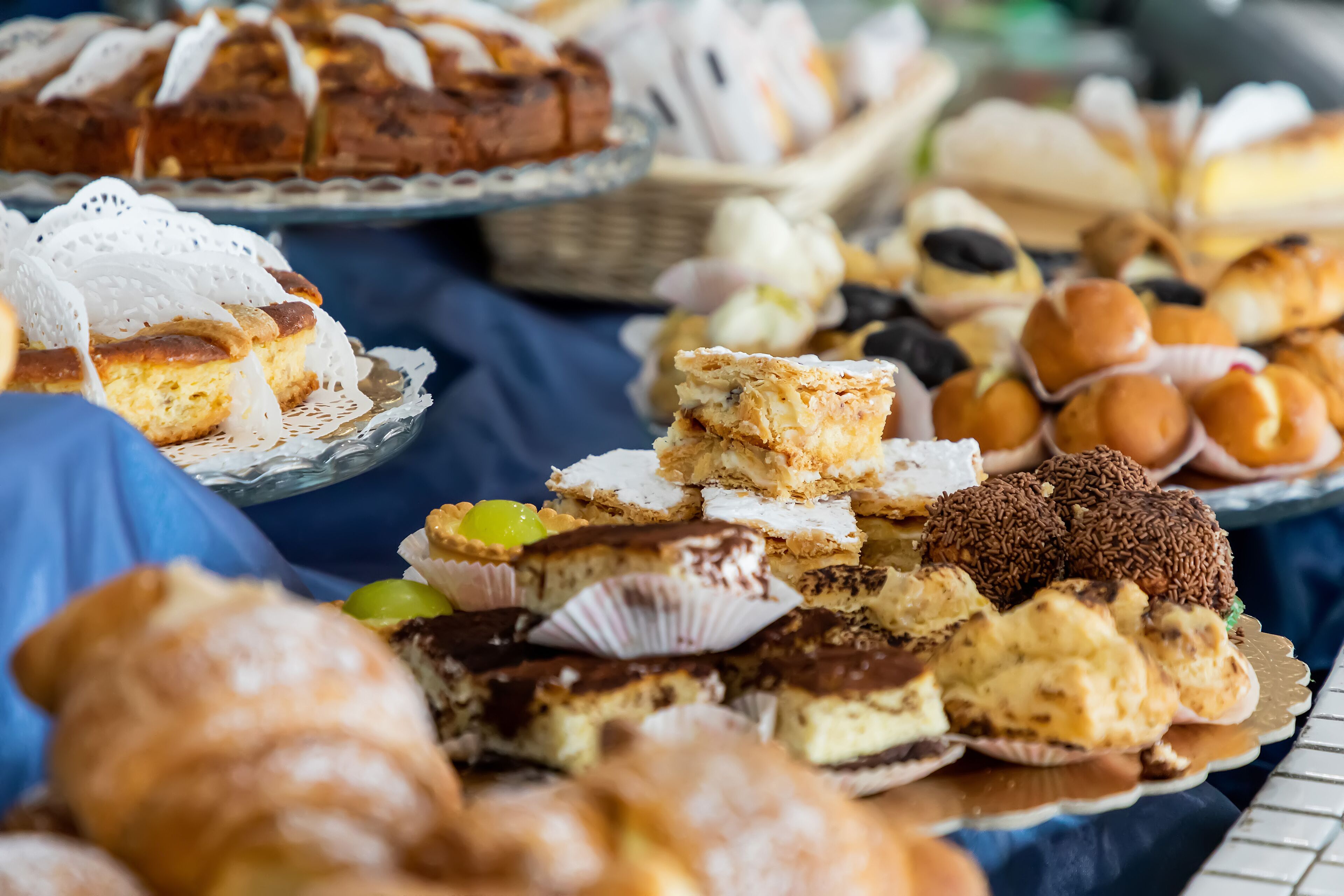 A variety of desserts on a table, including cakes, pastries, and tarts.