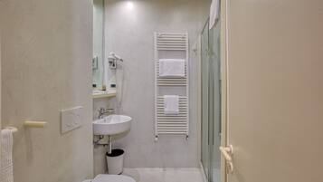 Ein kleines Badezimmer mit Toilette, Waschbecken und Duschkabine.