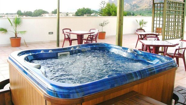 A hot tub on a rooftop terrace with potted plants and outdoor furniture. - Al Ritrovo Ristorante & Albergo (San Vito Lo Capo)