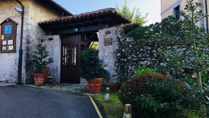 Un edificio rústico con fachada de piedra, puerta de madera y plantas en macetas.