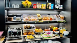 Una mesa de buffet con diversos alimentos, salsas y utensilios.