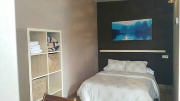 Un dormitorio con cama, armario y un cuadro en la pared.