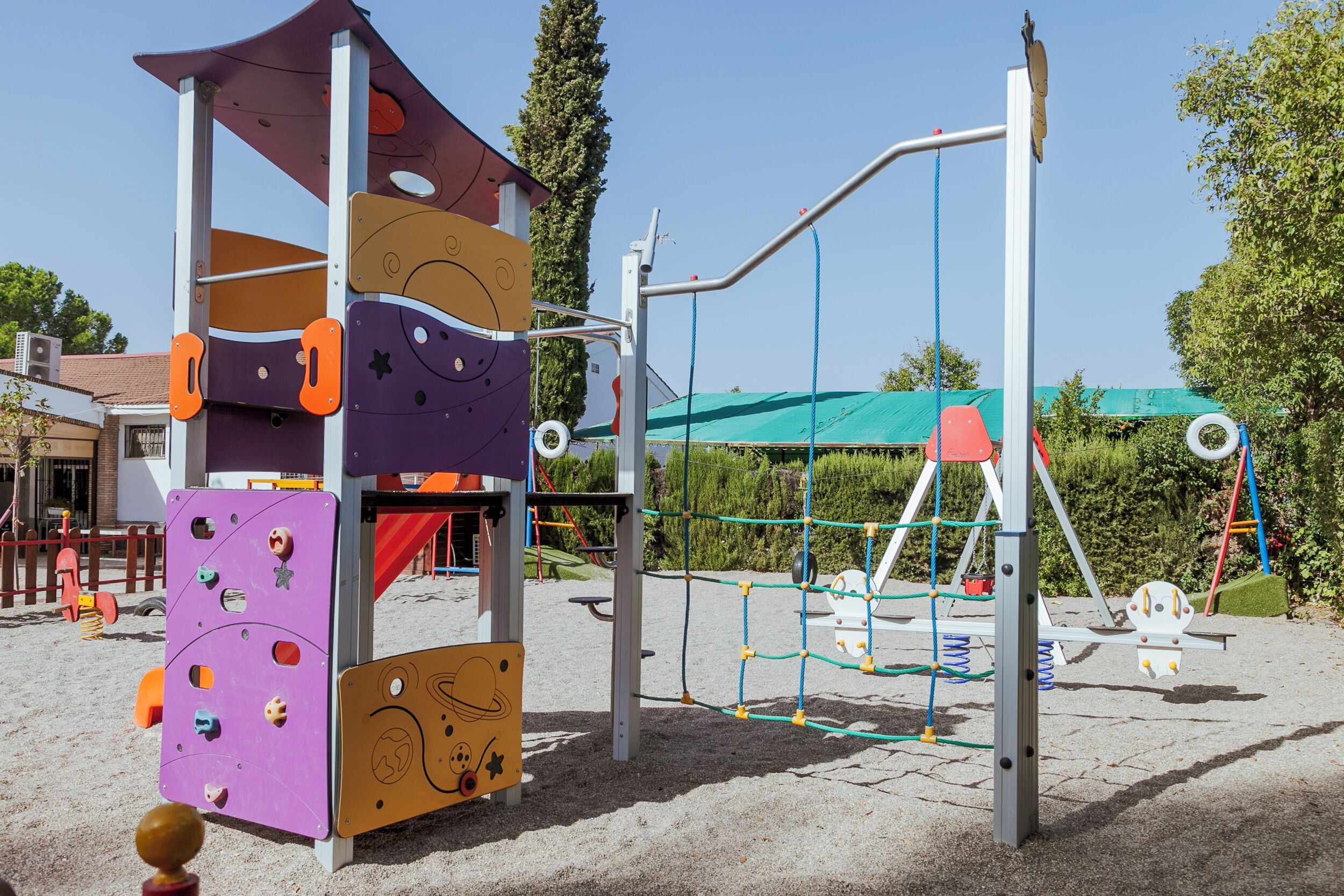 A playground with climbing structures, swings, and a slide.