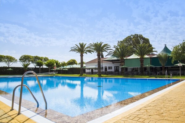 Een seizoensgebonden buitenzwembad en parasols bij het zwembad