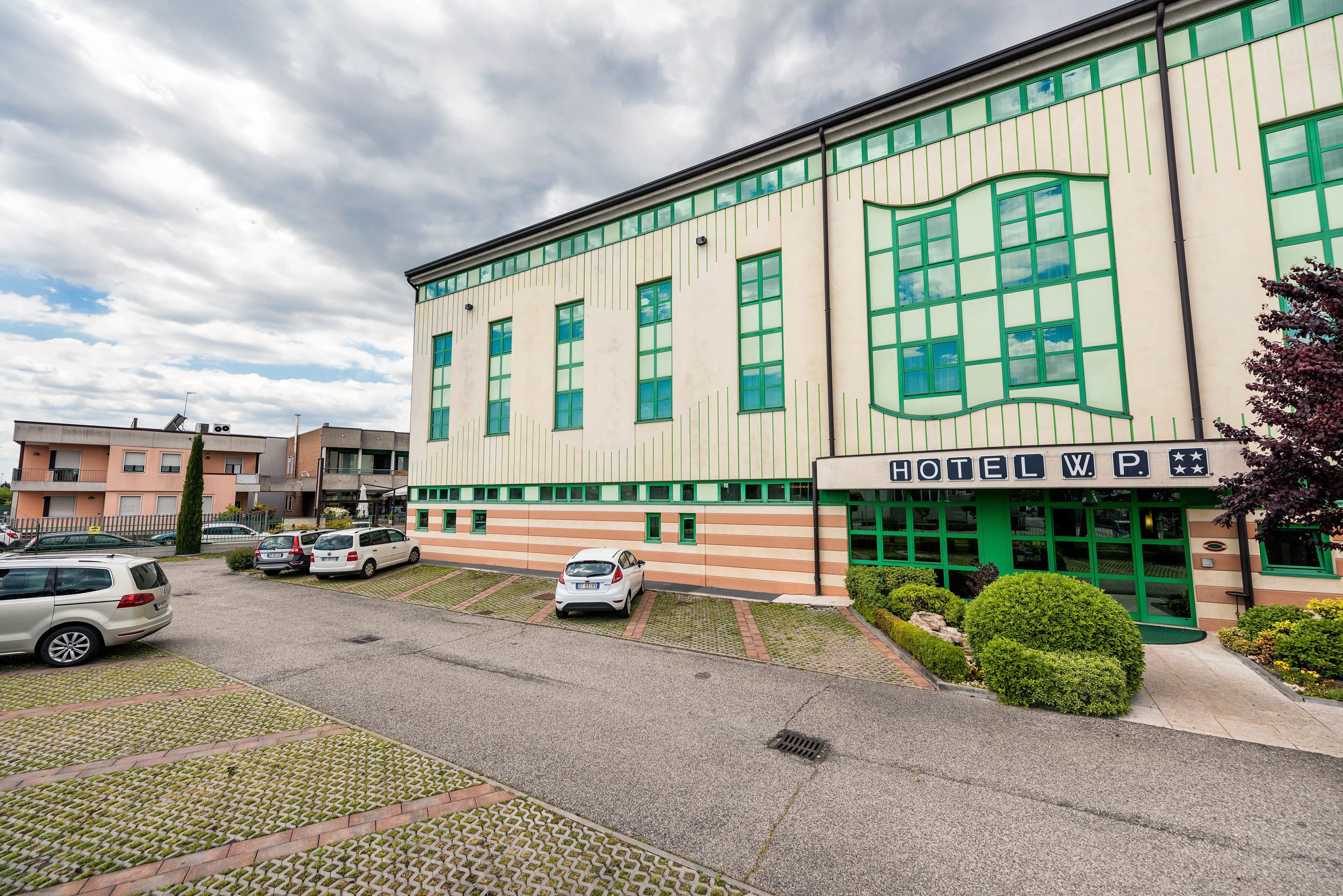A hotel with a modern facade, multiple parking spaces, and a well-maintained exterior.