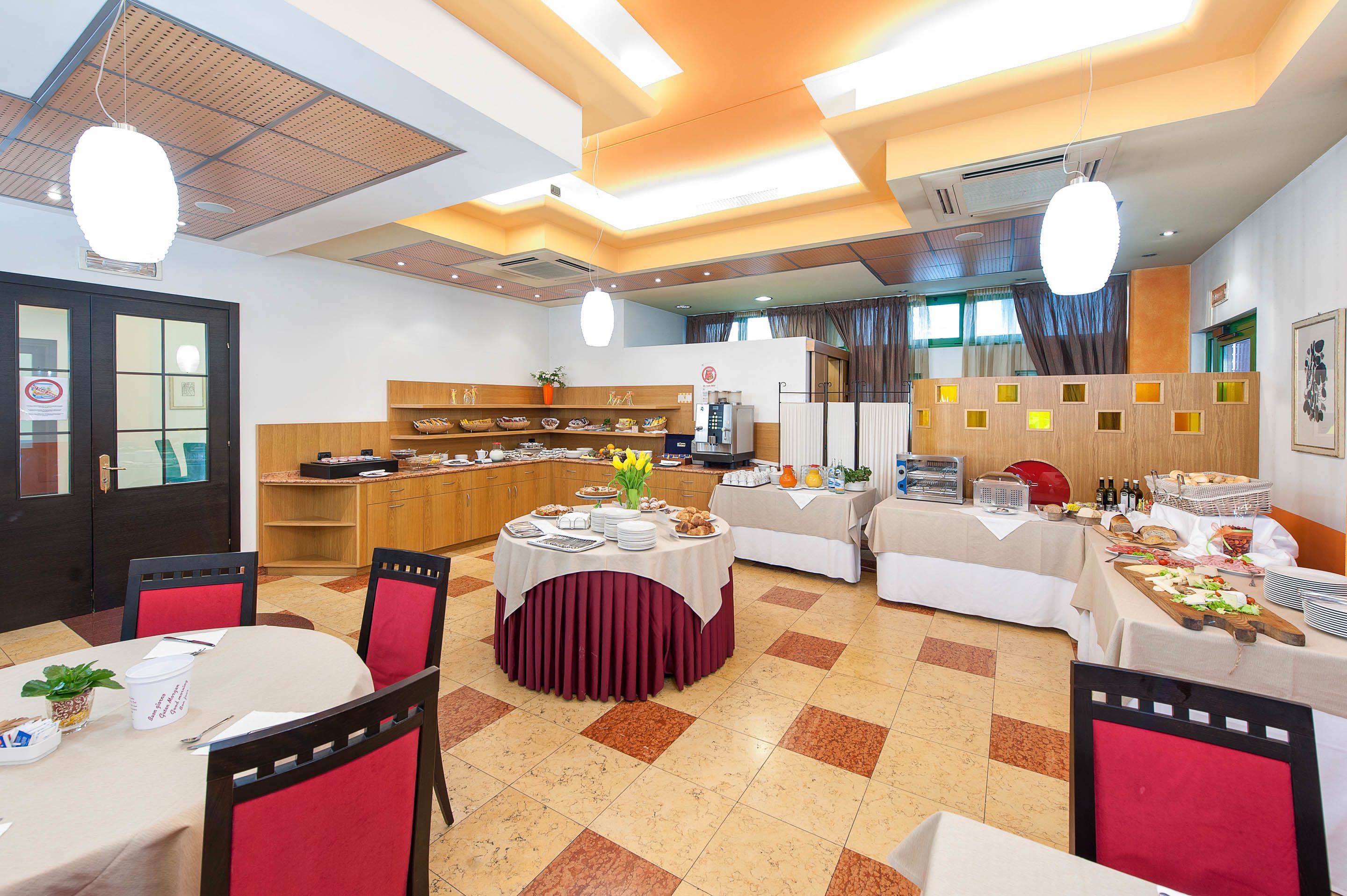 Un espace repas comprenant plusieurs tables, des chaises et un buffet.