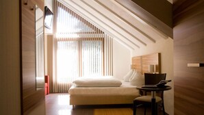 A modern bedroom with a bed, a desk, and a chair. - Parkhotel Lindau (Lindau)