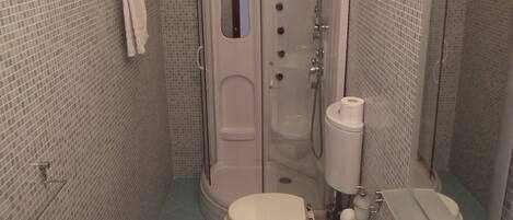 Une salle de bain équipée de toilettes, d’un bidet et d’un lavabo.