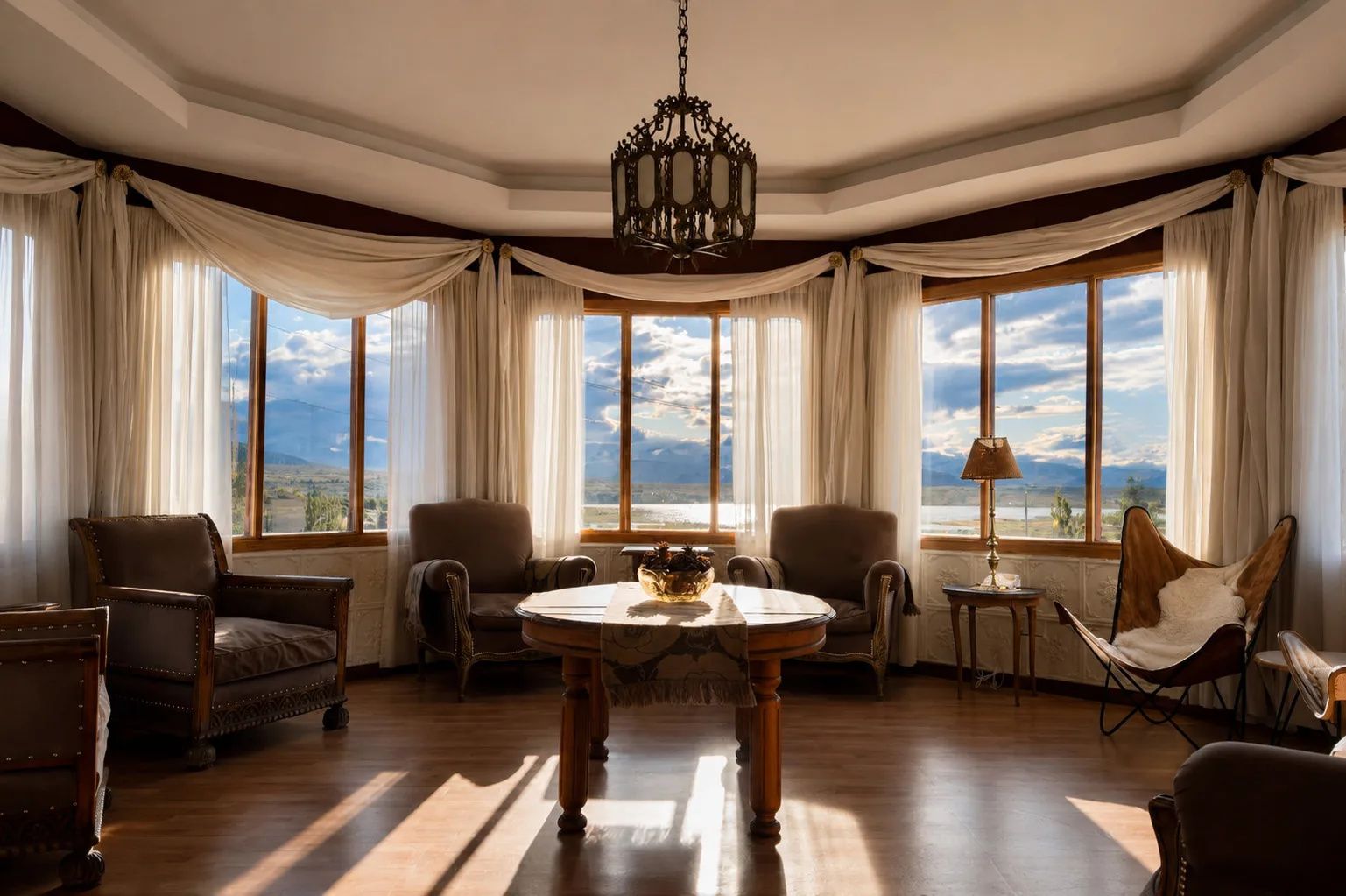 Una habitación con una mesa grande, varias sillas y vistas al paisaje a través de amplios ventanales.