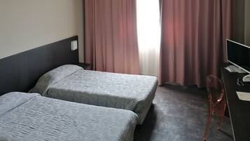 Una habitación de hotel con dos camas, un escritorio y una silla.