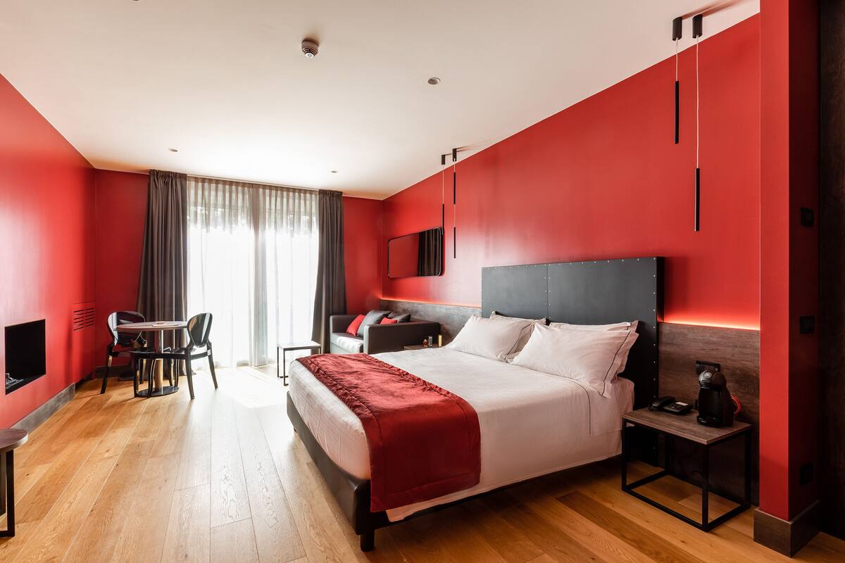 Ein modernes Hotelzimmer mit einem großen Bett, einem Schreibtisch und einem Sessel.