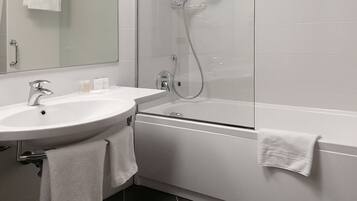 A modern bathroom with a white sink, mirror, and bathtub.