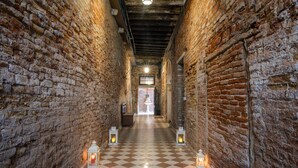A narrow corridor with brick walls, a checkered floor, and lanterns along the path. - Dimora al Doge Beato Vista Canale (Venice)