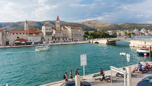 A waterfront view with a historic building, a bridge, and boats. - Vila Liza (Trogir)
