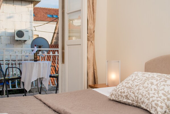 A bedroom with a bed, a table with a tablecloth, and a chair. - Vila Liza (Trogir)