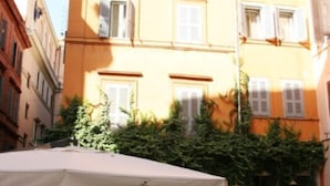 An outdoor café with tables and chairs, surrounded by buildings. - Trevi Beau Boutique Hotel (Rome)