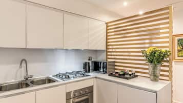 Appartement Deluxe, 2 chambres, vue ville, dans les dépendances | Cuisine privée | Batterie de cuisine, vaisselle et ustensiles