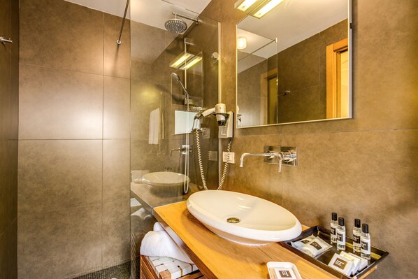 A modern bathroom with a large mirror, a sink, and a shower.