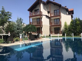 Una piscina al aire libre, sillones reclinables de piscina